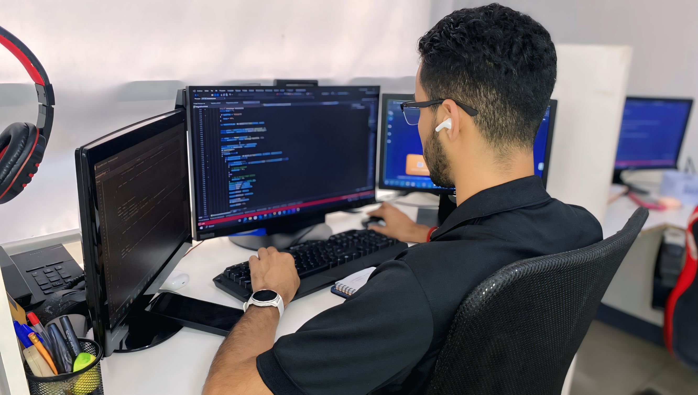 Programador de Magna IT Solutions desarrollando un software especializado para gestión de restaurantes, con código en pantalla.